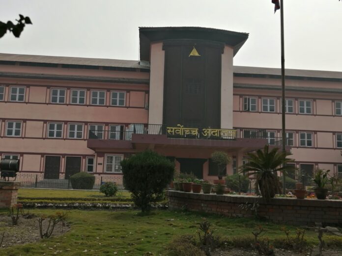 अगाडि बगैँचा र झन्डासहित सर्वोच्च अदालतको भवन।